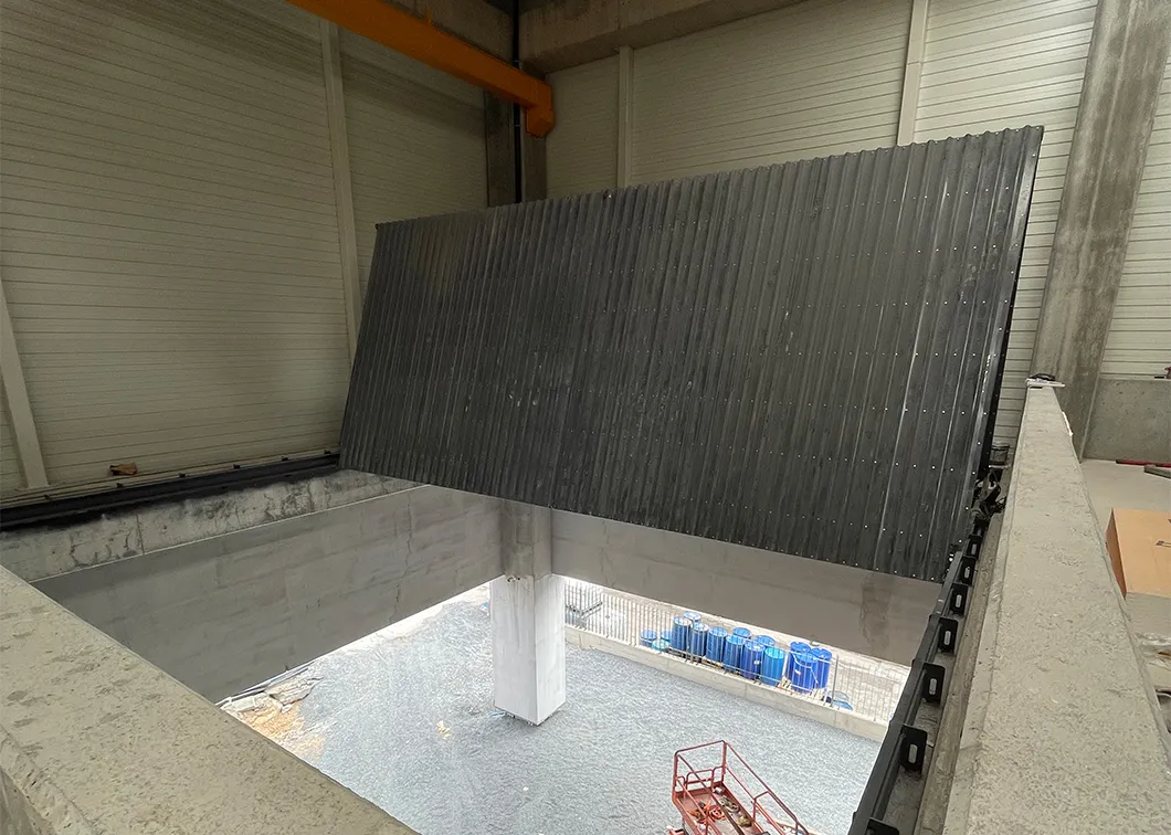 Folding hydraulic floor hatch raised in a factory